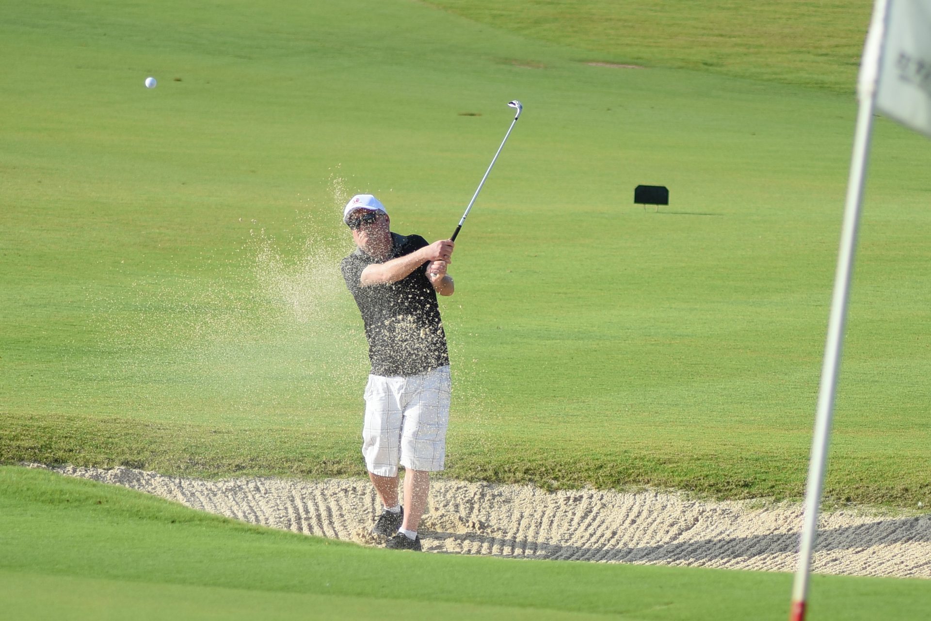Corporate golf tournament bunker shot action Cancún